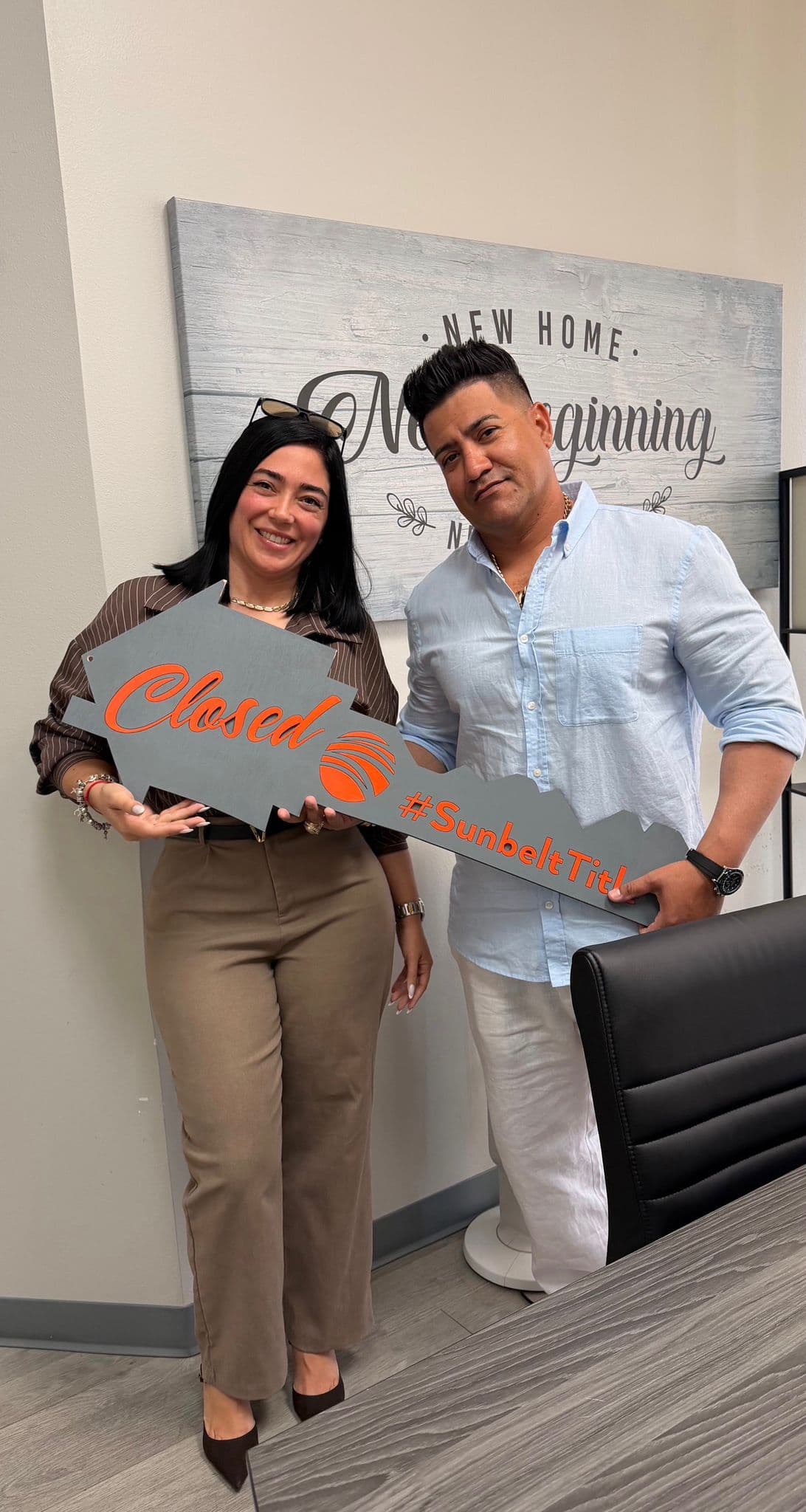 Lazara Diaz Tampa Bay Realtor handing over house keys to clients surrounded by HOME balloon letters
